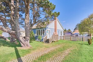 A welcoming entryway with a few stairs, surrounded by green grass and fresh coastal air.
