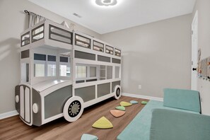 Kids room with bus bunked bed and toys for kids.