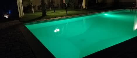 Veduta notturna e piscina con illuminazione a led colorati