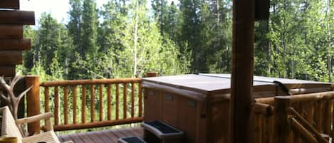 Incredible deck with hot tub and outdoor seating facing National Forest