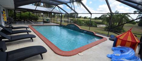 Our screened waterfall pool, with the golf course and pond in the background