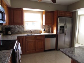 Newly renovated kitchen with stainless steel appliances and granite countertops.