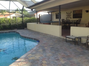 Huge Screened Patio area with Heated Pool, Jacuzzi, and lounge chairs.