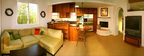 Panoramic view of living room and kitchen.