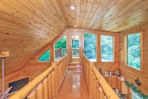 The catwalk loft leads to a separate deck to enjoy the wooded views