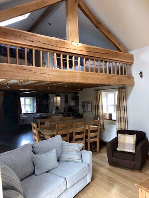 Open plan layout showing mezzanine sleeping deck above the dining area