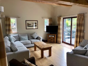 Spacious living room opening onto private patio with dining table & terrace.