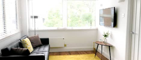 Living room: double aspect, with sofas, TV, dining table and 6 chairs