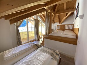 Upstairs bedroom with one double and two singles bed & a south facing balcony