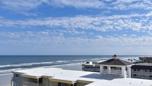 Beach views from the balcony, over a nearby building.