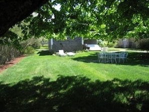 The large, quiet back yard with tables, chairs & grill, provides sun and shade. 