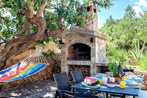 Shaded terrace under the Carob tree with traditional barbecue 