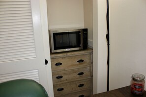Microwave and mini fridge is next to it behind the closet.
