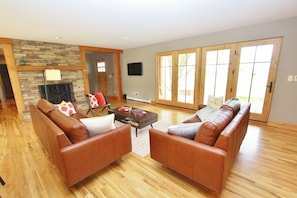 Living room features modern leather furniture, a fireplace, and an LCD TV.