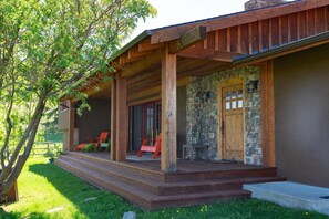 The front porch has seating for two in the shade, for enjoying summer evenings.