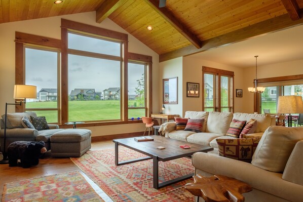 The living room wall of windows faces the common green space of the community