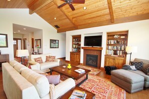 The living room has walls of shelves stocked with books, games and puzzles