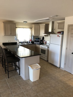 Granite island with full refrigerator, microwave, dishwasher and gas stove/oven