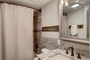 Full bath in entryway w/ custom granite counter top to match kitchen.