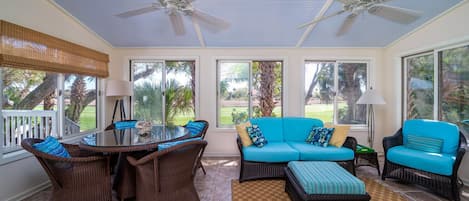The sunroom has amazing views of the 17th hole of Ocean Winds. Gather around the table and share stories from your day at the beach.