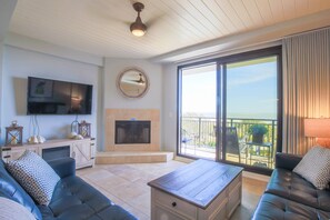 The living room features ocean views, access to a private balcony and shiplap ceilings.