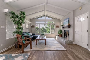 Living room with tall ceilings, window that faces lake, and lots of natural light