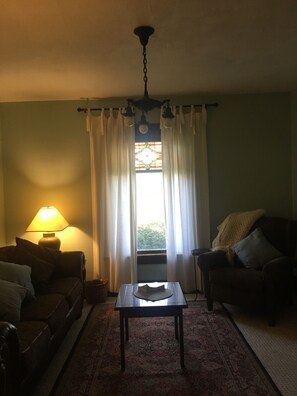 Living room with original stained glass window.