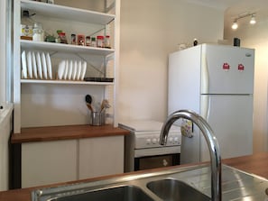 The kitchen has a full size fridge, electric stove and oven, a dishwasher