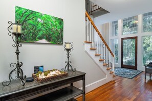 The front foyer is flooded with natural light, high ceilings, and opens to the main living spaces.