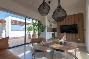 Living room with Smart TV, 42 inch HD with Netflix, Amazon Prime Video, Apple TV, HBO, Google Chromecast (you need to be a user to access the apps), satellite TV, air conditioning. (overlooking the front terrace)
