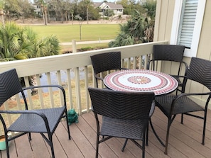 The front porch has a table set to enjoy the view wildlife in the lagoon and the golf course.
