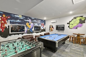 Featuring a foosball table, pool table, gaming system and table and chairs