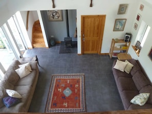 Looking down from the mezzanine to the living area with woodburner