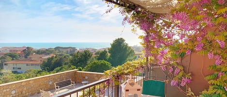 Terrazzo vista mare con fiori, tavolo per 4 persone e sdraio. Beautiful terrace