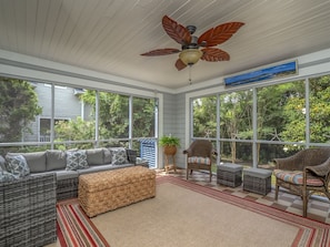 Large screen porch has seating area.