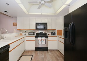 Oven range, microwave, and fridge in the kitchen.