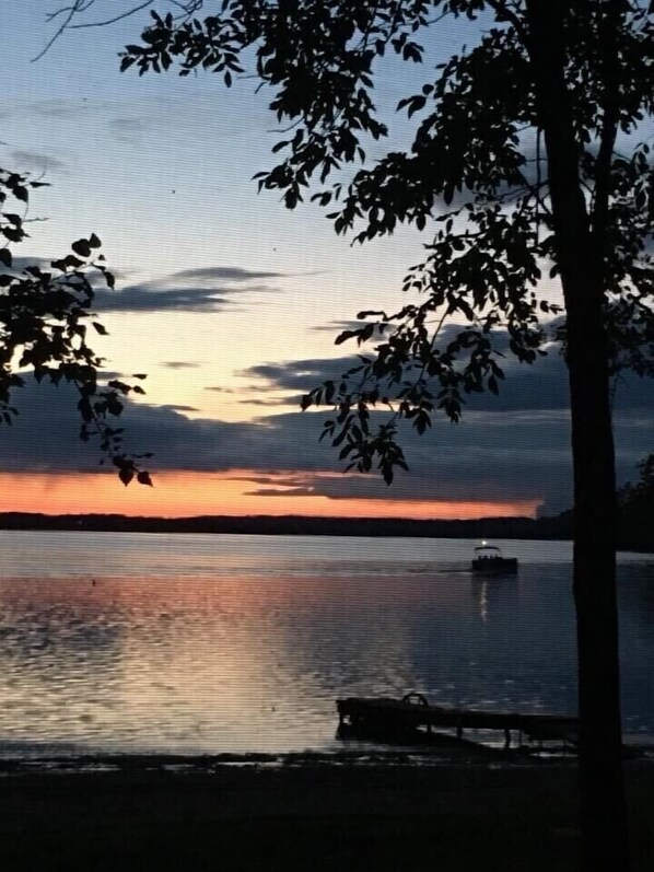 Pontoon boat going by at sunset.