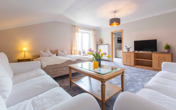 Wohnzimmer mit Couchen und Doppelbett