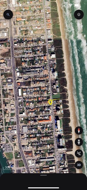 Aerial view.  Circled in yellow, house is directly across the street from beach.