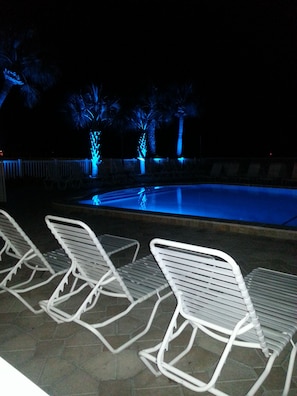 Pool at nighttime with beautiful blue lights around all landscaping 

