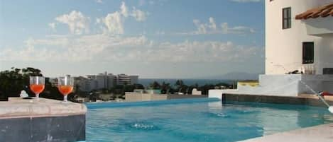 Pool with  jacuzzi sits in the courtyard.