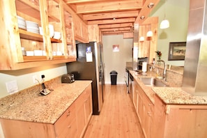 Well stocked kitchen with ample granite counters including breakfast bar
