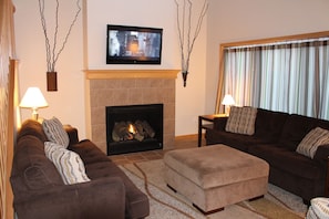 Living room with two couches, love seat, ottoman, gas fireplace and cable TV