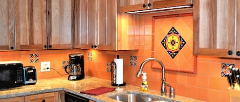 Kitchen has new granite surface and tile backsplash