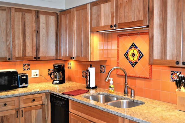 Kitchen has new granite surface and tile backsplash