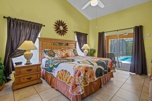 Master bedroom with king bed, walk-in closet, 65" Smart TV, and pool access