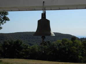 Original dinner bell hangs from porch.