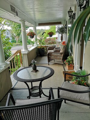 Front porch with lounge area and an area to enjoy a drink or meal.