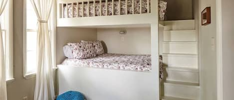 Built-in queen size bunk beds define the back bedroom. With four beds (two queens, a full, and a twin), this room can accommodate a large family or group. The former sun porch has now been enclosed, but we've restored its rich, dark oak ceiling.  