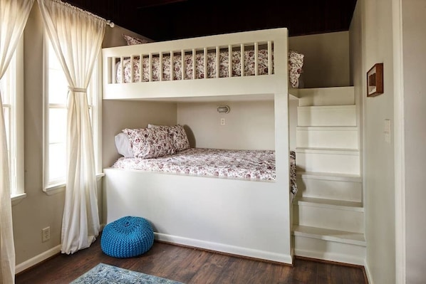 Built-in queen size bunk beds define the back bedroom. With four beds (two queens, a full, and a twin), this room can accommodate a large family or group. The former sun porch has now been enclosed, but we've restored its rich, dark oak ceiling.  